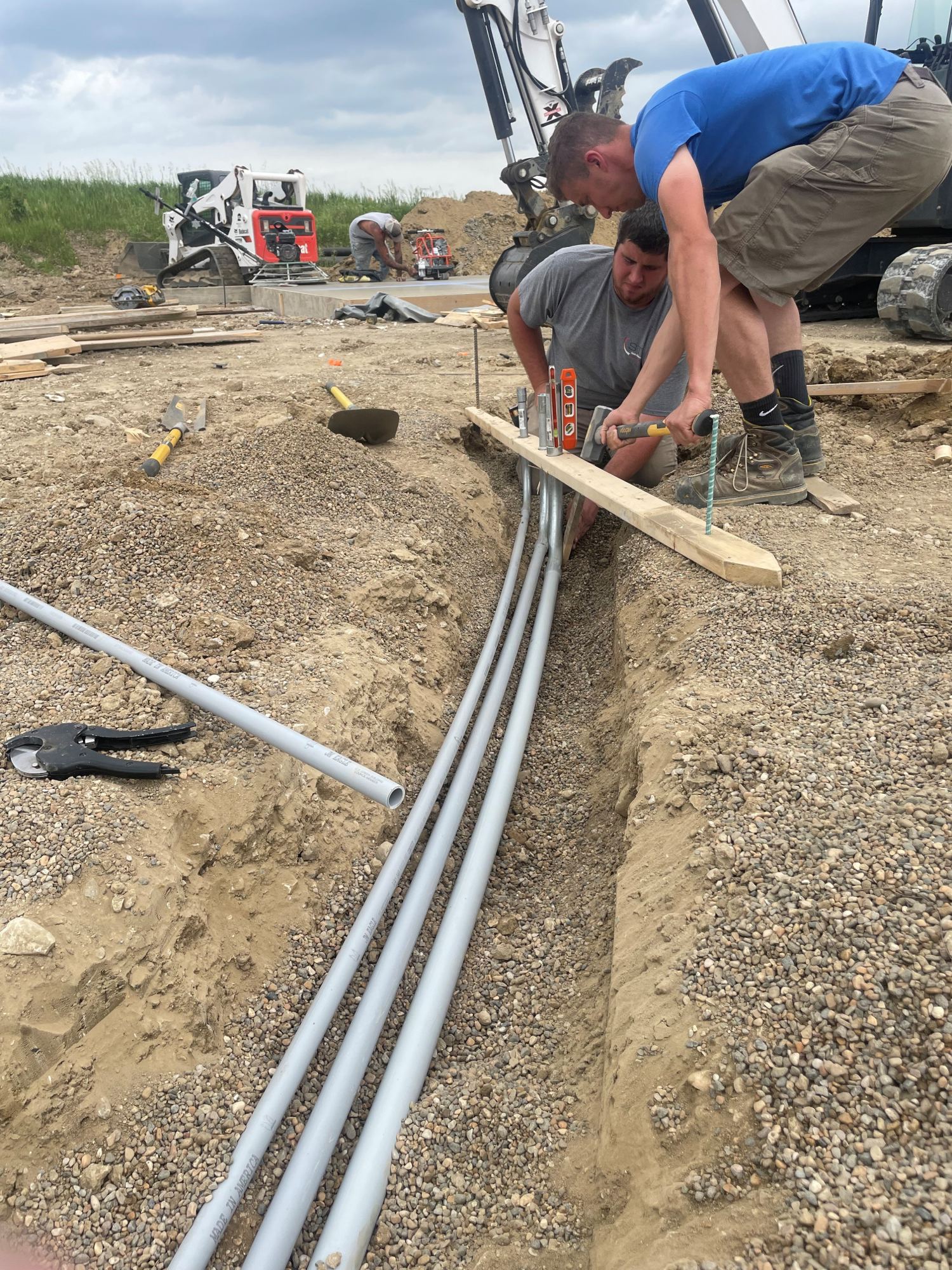 MG Electric crew installing underground conduit runs at a trenching jobsite